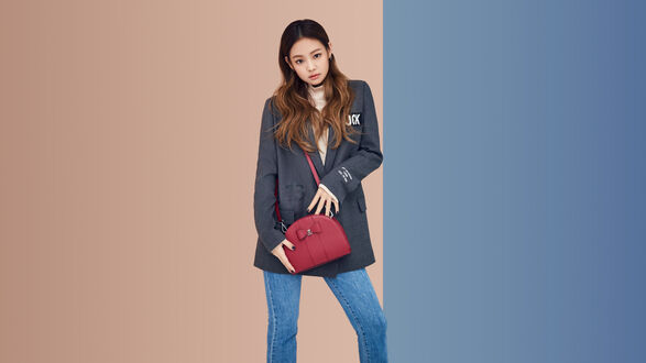 Обои на рабочий стол Ким Дженни / Kim Jennie из BLACKPINK с малиновой сумочкой и в джинсах на бежево-синем фоне