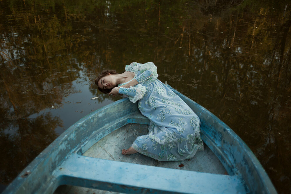 Обои для рабочего стола Модель Николь Андреа в нежно голубом платье лежит в лодке, опустив голову к воде