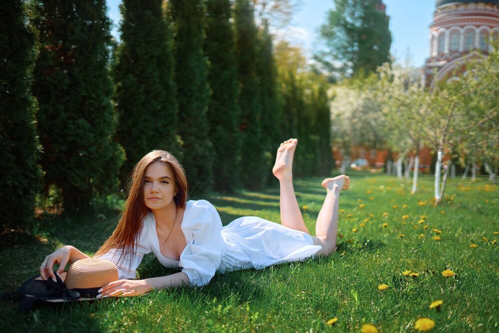 Обои для рабочего стола Модель Дарья в белом платье лежит на траве в саду