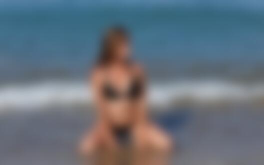 Обои для рабочего стола Красивая сексуальная девушка в черном купальнике на пляже на фоне моря