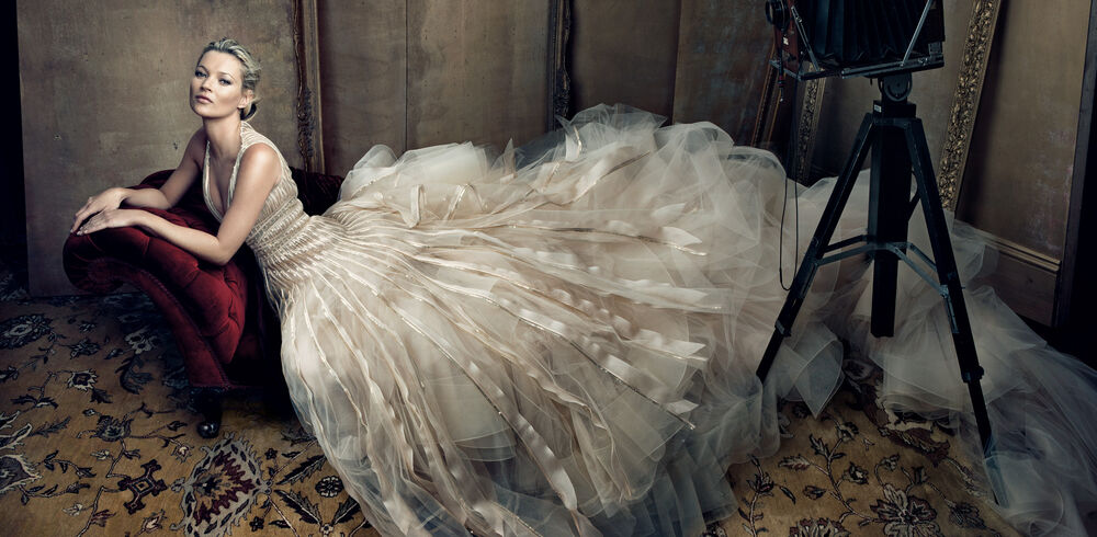 Обои для рабочего стола Британская супермодель и актриса Кейт Мосс / Kate Moss в длинном белом платье позирует на диване