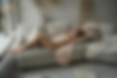 Обои на рабочий стол Модель Milky Kiss в расстегнутом платье лежит на диване в комнате