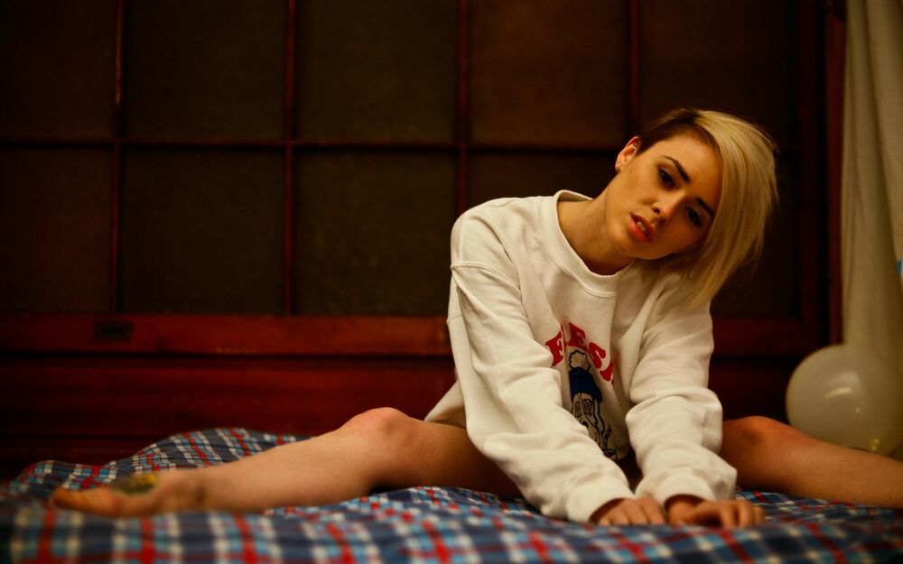 Обои для рабочего стола Девушка - модель Alysha Nett в кровати с клетчатым покрывалом в светлом свитшоте