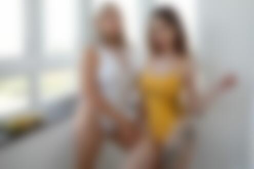 Обои для рабочего стола Модели Софья и Наталья в белом и в желтом купальниках стоят в комнате на фоне окна