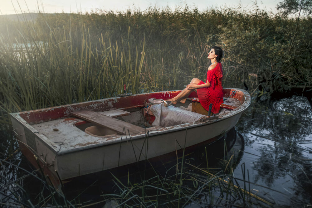 Обои для рабочего стола Девушка в красном платье сидит в лодке