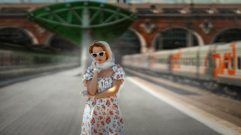 Обои для рабочего стола Модель Марина в платке, в темных очках и в цветастом платье стоит на перроне вокзала