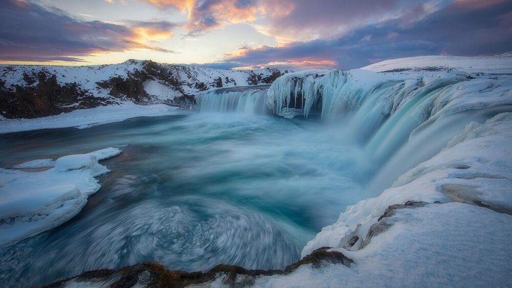 Обои для рабочего стола Годафосс Водопад в ИсландииИсландии, в регионе Нордюрланд-Эйстра на закате с берегами покрытыми льдом