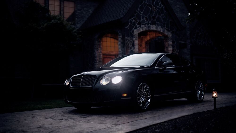 Обои для рабочего стола Bentley Continental GT в черном цвете, ночью, возле старого особняка