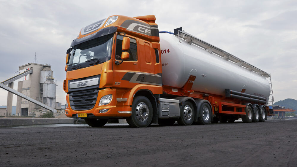 Обои для рабочего стола Оранжевый самосвал DAF с цистерной на дороге