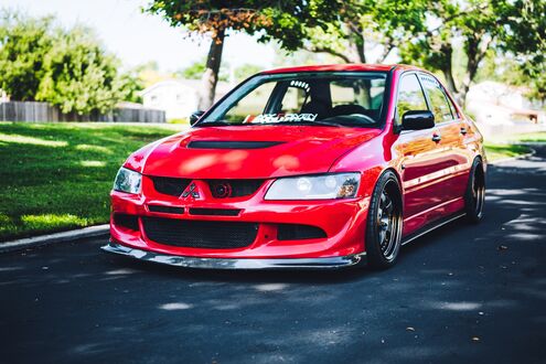 Обои на рабочий стол Красный Mitsubishi lancer Evolution 7 на дороге