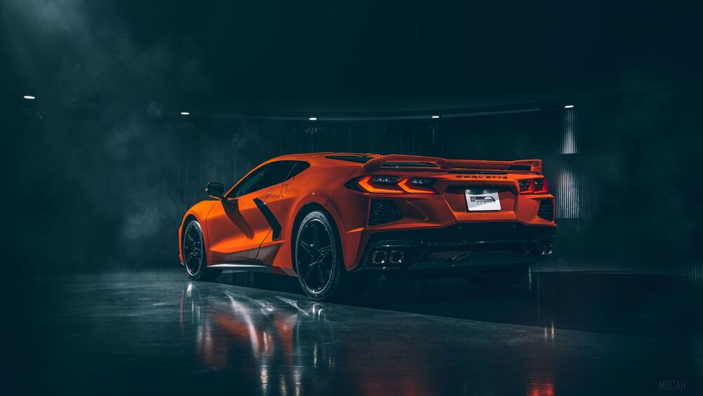 Обои для рабочего стола Освещенный оранжевый спорт-кар Chevrolet Corvette Stingray C8, стоит в темном задымленном помещении со светящимися фонарями, вид сзади