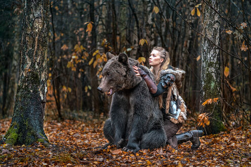 Татуировка мужская black&grey на предплечье девушка в шкуре медведя