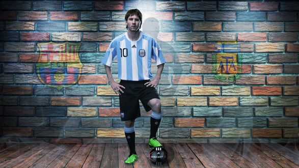 Обои на рабочий стол Звезда футбола Leonel Messi / Леонель Месси стоит с мячом в форме сборной Аргентины, на фоне расписанной стены с эмблемами ФК Барселона и Аргентины