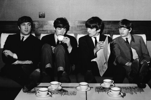 Обои на рабочий стол Легендарная британская четверка The Beatles (John Lennon, Paul McCartney, George Harrison, Ringo Starr) сидят за столом и пьют чай
