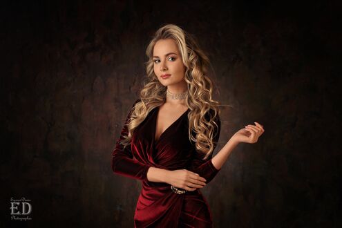 Обои на рабочий стол Модель Katya Khalpert / Катя Халперт позирует стоя в бордовом бархатном платье, на фоне темной стены