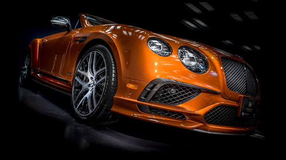Обои на рабочий стол Оранжевая Bentley на черном фоне