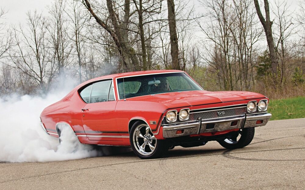 Обои для рабочего стола Дым из под колес красного Chevrolet chevelle среди осенней природы
