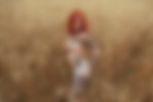 Обои для рабочего стола Рыжеволосая девушка с тату топлес стоит в колосящемся поле и прикрывает рукой грудь