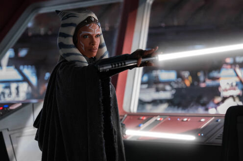 Обои на рабочий стол Розарио Доусон в роли Асока Тано / Ahsoka Tano стоит с поднятым световым мечом в руке из сериала Асока (2023)