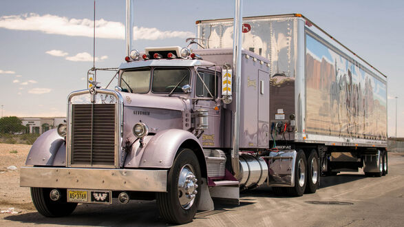 Обои на рабочий стол Тягач Kenworth с блестящим прицепом стоит на трассе
