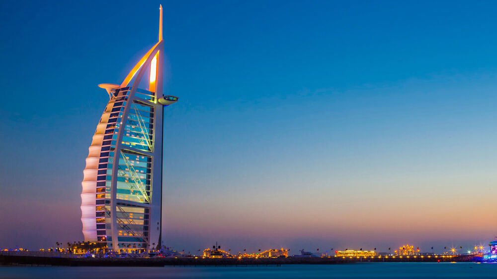 Обои для рабочего стола Отель Бурдж-эль-Араб / Burj Al Arab в Дубае, ОАЭ / Dubai, UAE на закате вид с воды
