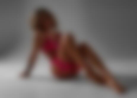 Обои на рабочий стол Модель Анна в розовом нижнем белье сидит на темном фоне на полу помещения