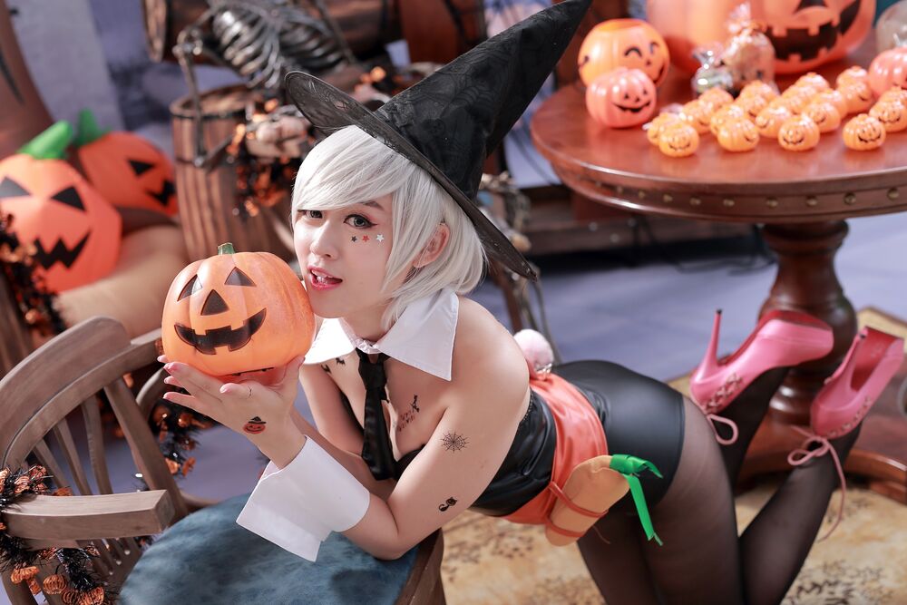 Обои для рабочего стола Девушка азиатка с белыми волосами в костюме ведьмы с резной Хэллоуинской тыквой в руках стоит на коленях