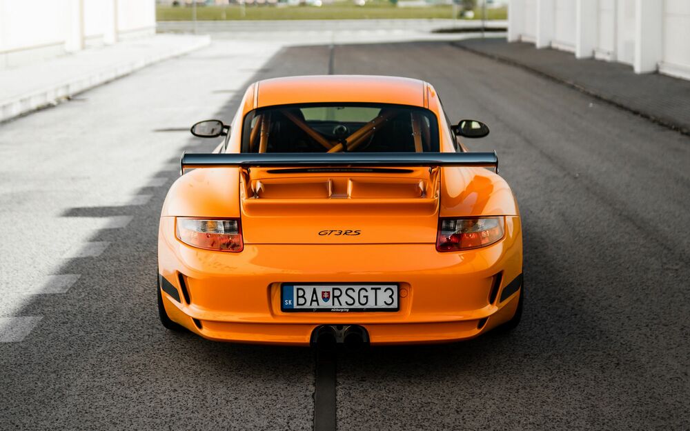 Обои для рабочего стола Оранжевый Porsche GT 3RS в солнечный день на дороге