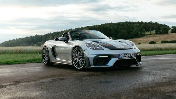 Обои на рабочий стол Белй Porsche 718 Spyder RS Weissach на фоне полей с лесом в далеке