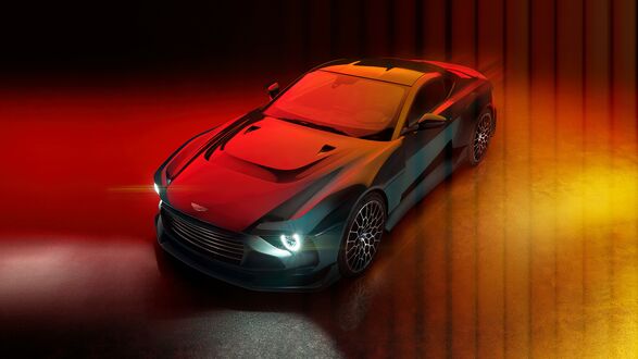 Обои на рабочий стол Темный Aston Martin Valour 2024 на красном фоне с включенными фарами