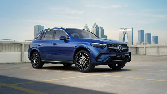 Обои на рабочий стол Голубой Mercedes - Benz GLC 2023 на фоне небоскребов города