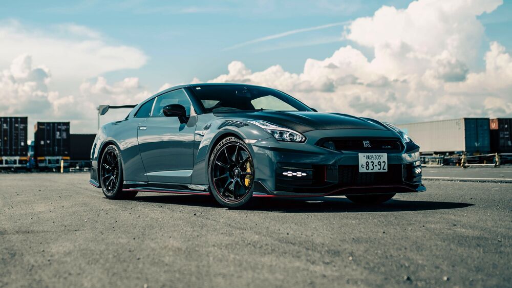 Обои для рабочего стола Зеленый Nissan GT-R Nismo Special Edition среди грузовых контейнеров