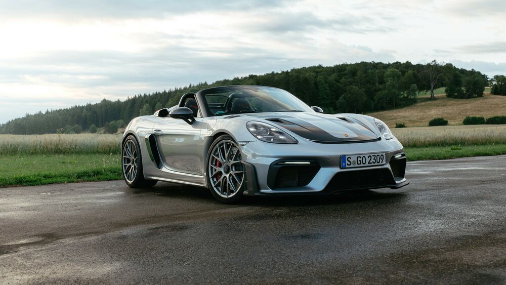 Обои для рабочего стола Белй Porsche 718 Spyder RS Weissach на фоне полей с лесом в далеке