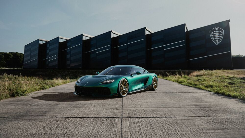 Обои для рабочего стола Зеленая Koenigsegg Gemera 2024 на фоне черного здания
