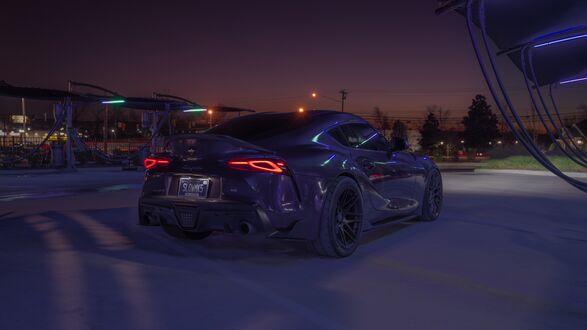 Обои на рабочий стол Toyota Supra темного цвета ночью на парковке