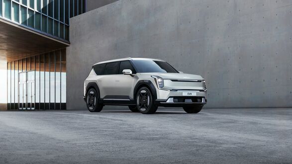 Обои на рабочий стол Белый Kia EV9 2023 у серой стены