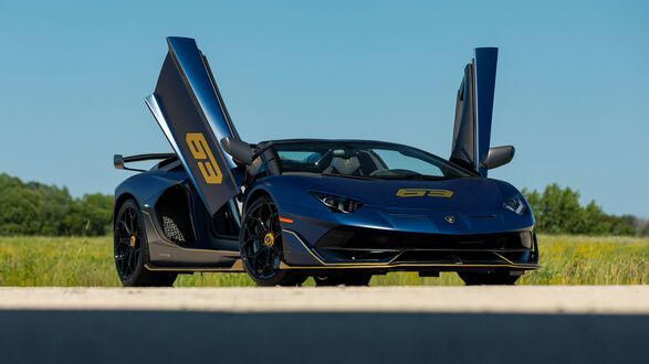 Обои на рабочий стол Темный Lamborghini Aventador SVJ 63 Roadster с открытыми дверьми на проселочной дороге
