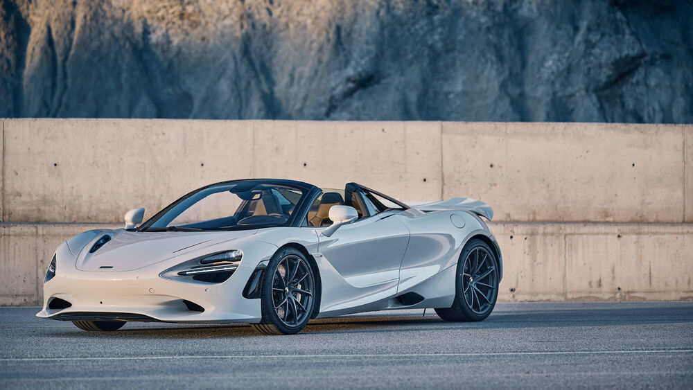 Обои для рабочего стола Белый McLaren 750S Spider на дороге у бетонной стены