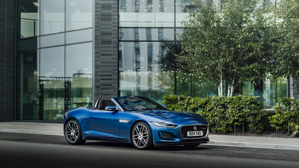 Обои для рабочего стола Синий Jaguar F-Type SVR Convertible стоит у офисного здания