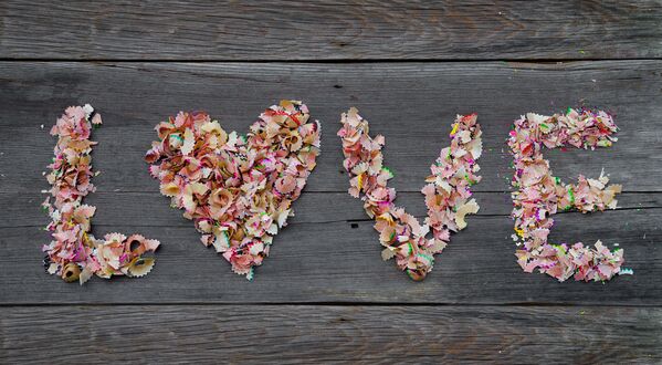 Обои на рабочий стол Фраза love из стружки от разноцветных карандашей