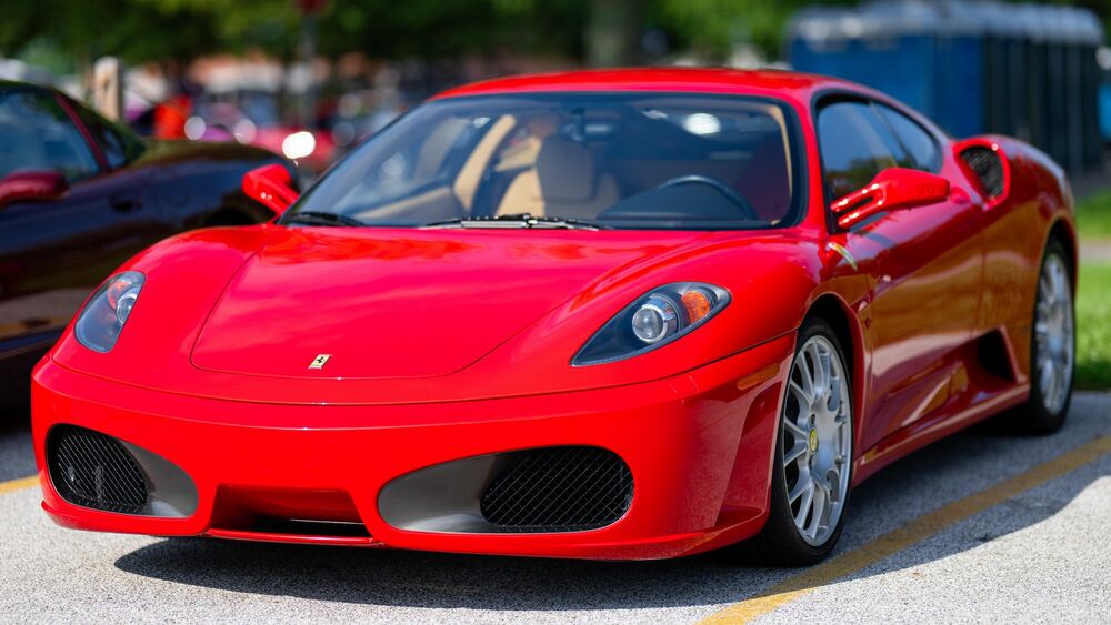 Обои для рабочего стола Красный Ferrari F430 на дороге на фоне парка