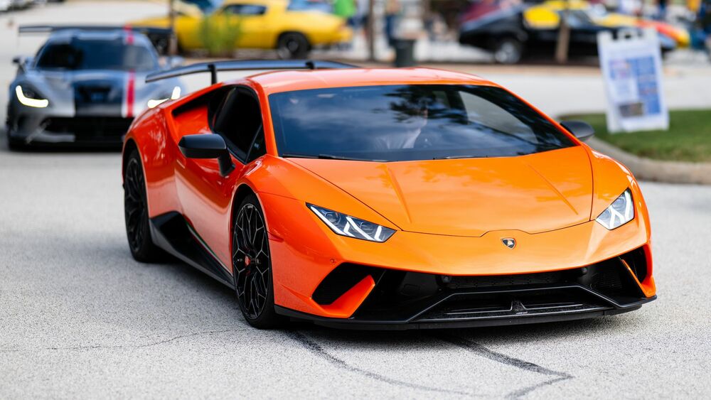 Обои для рабочего стола Оранжевый Lamborghini Huracán на дороге на выставке гоночных автомобилей