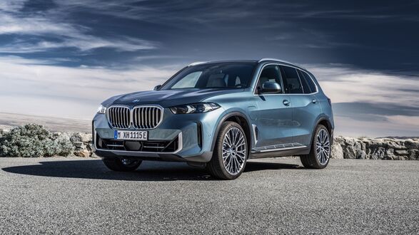 Обои на рабочий стол Голубой BMW X5 стоит на обочине дороги