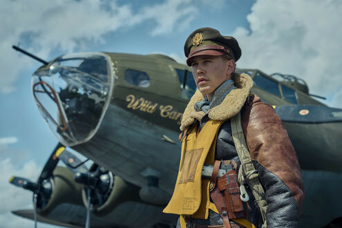 Обои на рабочий стол Остин Батлер (Austin Butler) в роли Гейла Клевена из сериала Властелины воздуха (Masters of the Air) стоит на фоне самолета