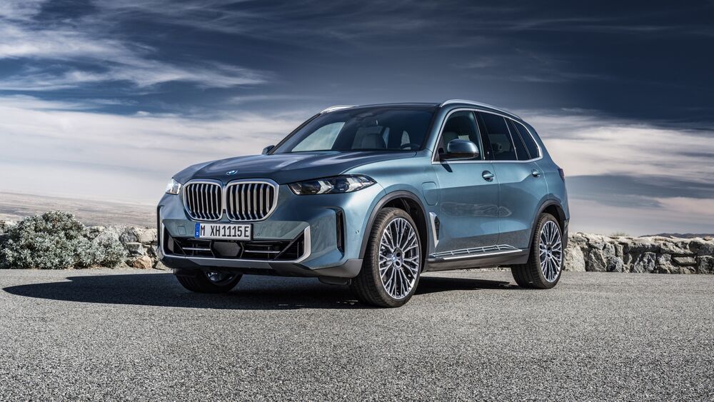 Обои для рабочего стола Голубой BMW X5 стоит на обочине дороги