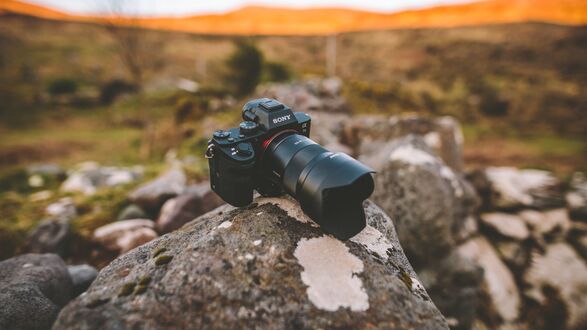 Обои на рабочий стол Зеркальная фотокамера Sony лежащая на валуне