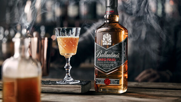Обои на рабочий стол Бутылка виски Ballantines рядом с бокалом на темном фоне в дыму