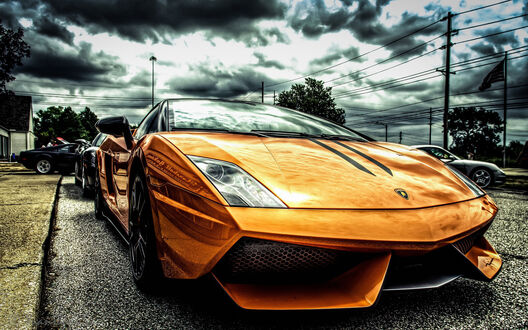 Обои на рабочий стол Оранжевый Lamborghini под пасмурным небом на дороге