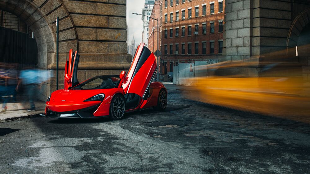 Обои для рабочего стола Красный McLaren 570S с открытыми дверьми в городе