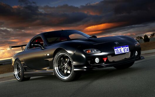 Обои на рабочий стол Черная Mazda RX-7 на асфальте на закате